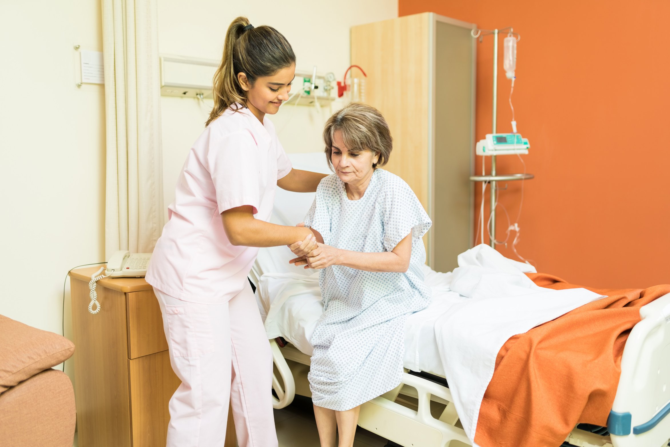 Healthcare Worker Assisting Elderly Patient In Hospital